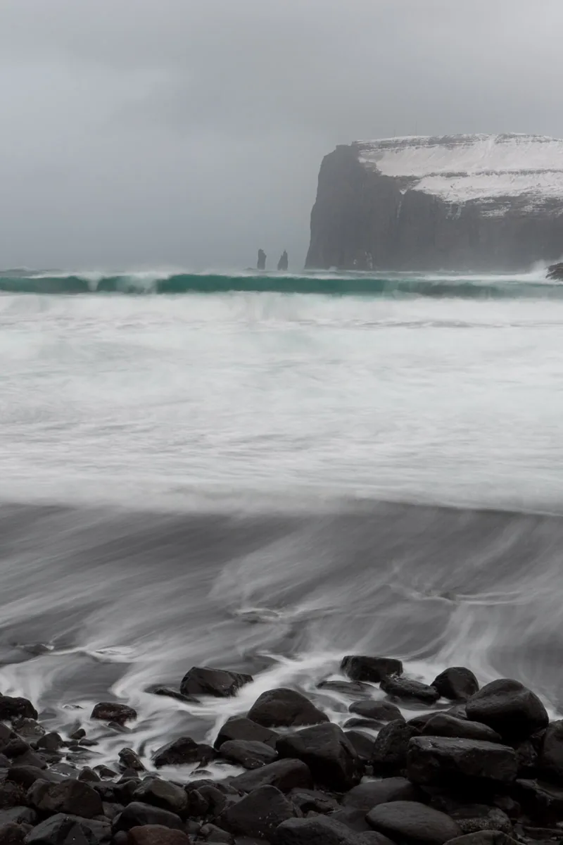 Tjornuvik beach with the stormy sea and a view of the Risin and Kellingin sea stacks